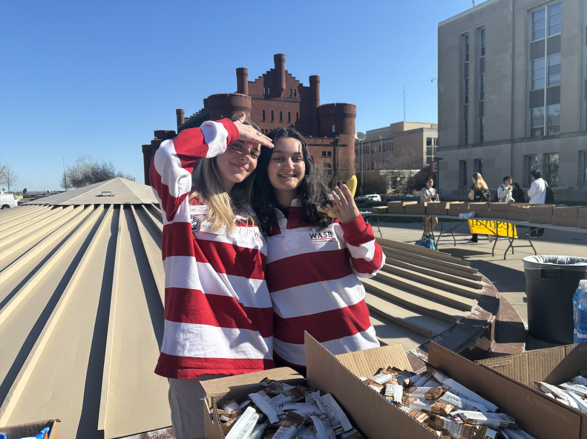 On Library Mall, WASB members Anabela Milicic (left) and Aanika Bereny (right) hand out granola bars as part of WASBs All-Campus Party.